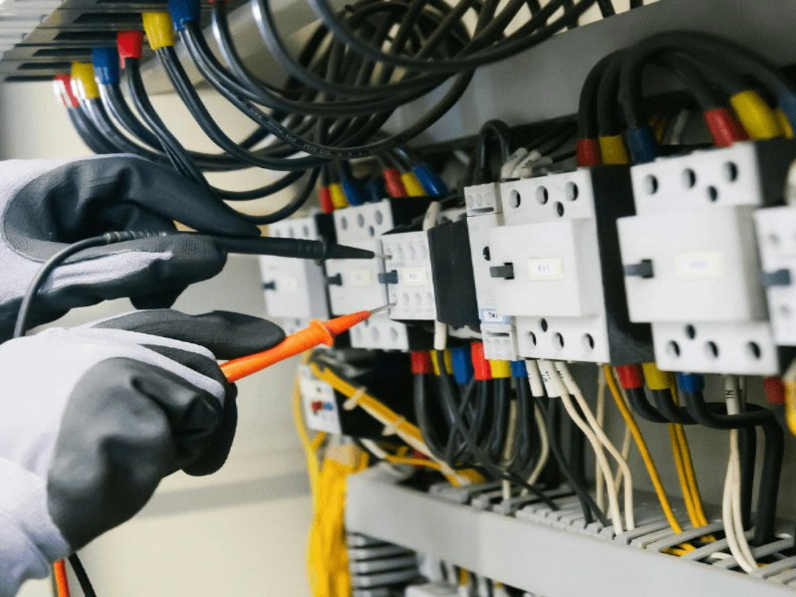 Electrician testing an electrical panel with a multimeter